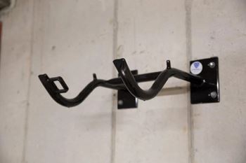 A black metal bracket is mounted on a white wall.